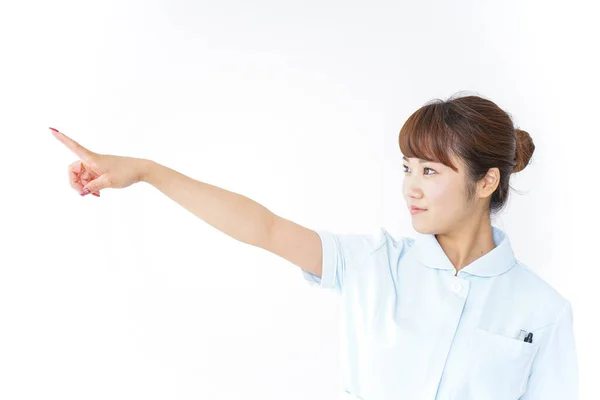 Junge Asiatische Krankenschwester Zeigt Mit Dem Finger Auf Weißem Hintergrund — Stockfoto