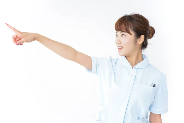 Junge Asiatische Krankenschwester Zeigt Mit Dem Finger Auf Weißem Hintergrund — Stockfoto