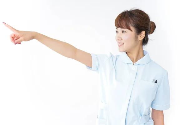 Junge Asiatische Krankenschwester Zeigt Mit Dem Finger Auf Weißem Hintergrund — Stockfoto