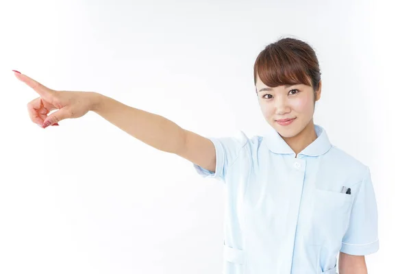 Junge Asiatische Krankenschwester Zeigt Mit Dem Finger Auf Weißem Hintergrund — Stockfoto