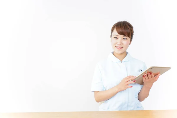 持有数码平板电脑的年轻亚洲护士 — 图库照片