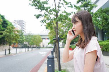 Genç Asyalı kadın caddeden arıyor.