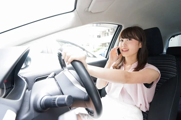 スマートフォンでアジアの若い女性を運転する — ストック写真