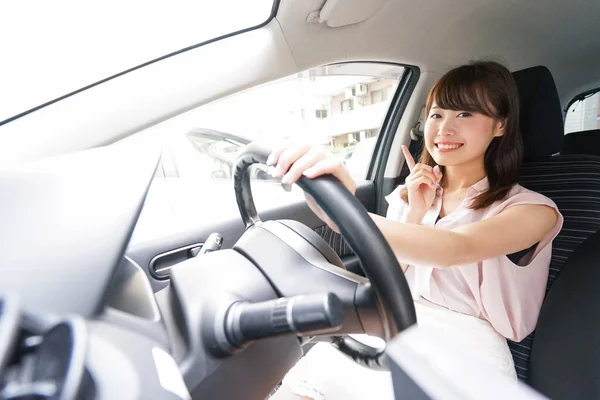若いアジアの女性ドライバーが何かを指して — ストック写真