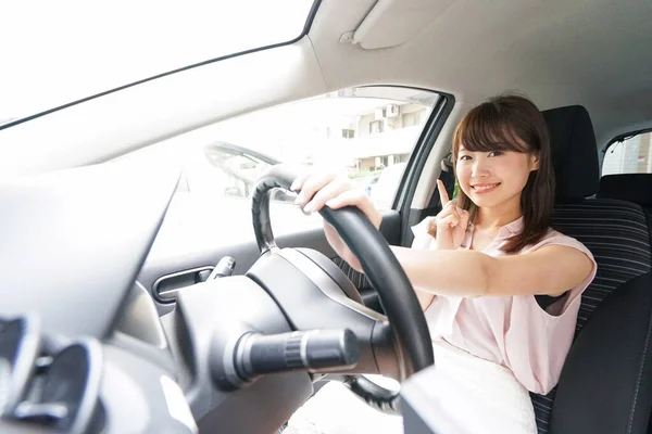 若いアジアの女性ドライバーが何かを指して — ストック写真
