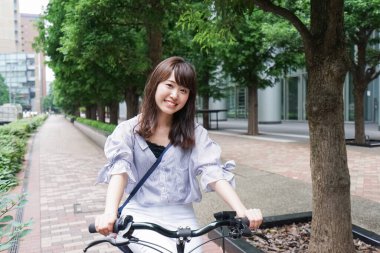 Bisiklete binen genç Asyalı kadın.