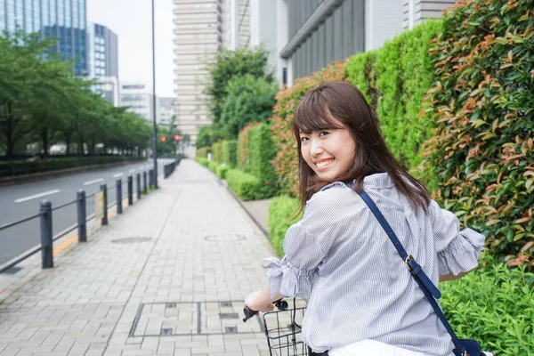 年轻的亚洲女人骑自行车 — 图库照片