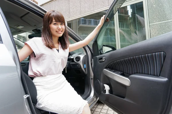 若いアジアの女性が車から出て — ストック写真