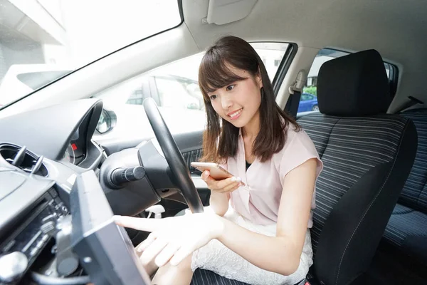 車のナビゲーションを使う若いアジア人女性 — ストック写真