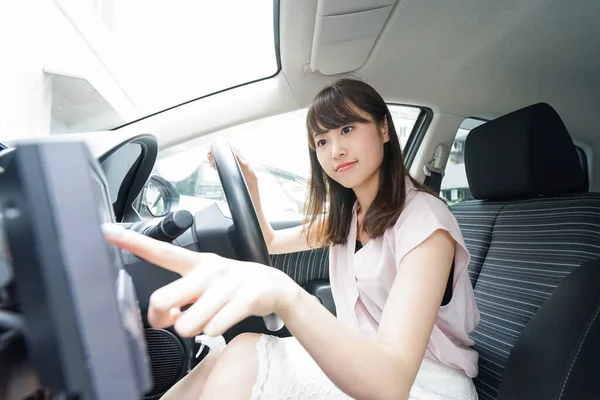 車のナビゲーションを使う若いアジア人女性 — ストック写真