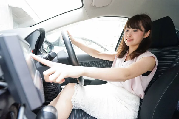 車のナビゲーションを使う若いアジア人女性 — ストック写真