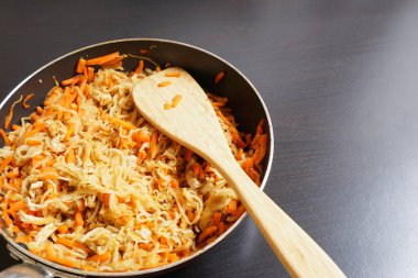 Daikon şeritleri ve tavada turpla ahşap spatula.