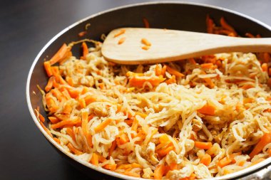 Daikon şeritleri ve tavada turpla ahşap spatula.