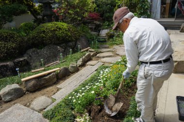 Bahçede çalışan yaşlı adam.
