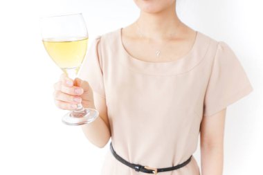 Genç ve güzel bir kadın beyaz arka planda izole edilmiş camdan şampanya içiyor.