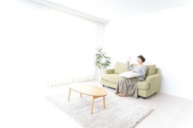 Bekar bir kadın, evinde, kanepede dinleniyor.