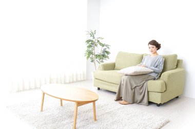 Bekar bir kadın, evinde, kanepede dinleniyor.