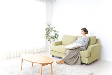 Kanepede televizyon izleyen bir kadın.