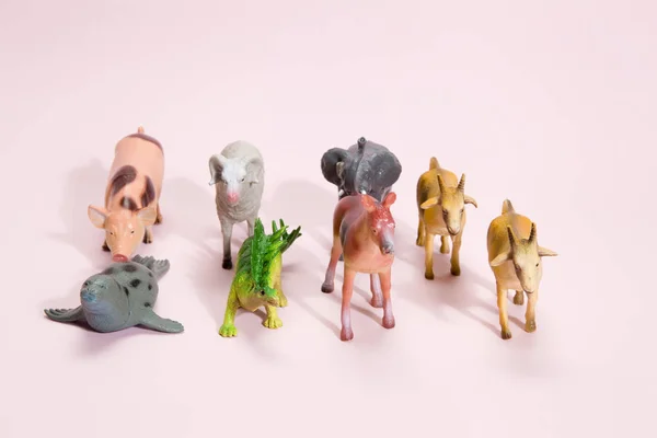 Тварини пластикові фігурки рожевий фон — стокове фото