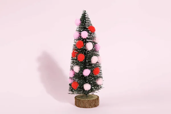 Verschneiter Weihnachtsbaum mit Pompons geschmückt — Stockfoto