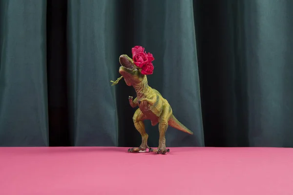 Динозавр, поедающий красные розы — стоковое фото