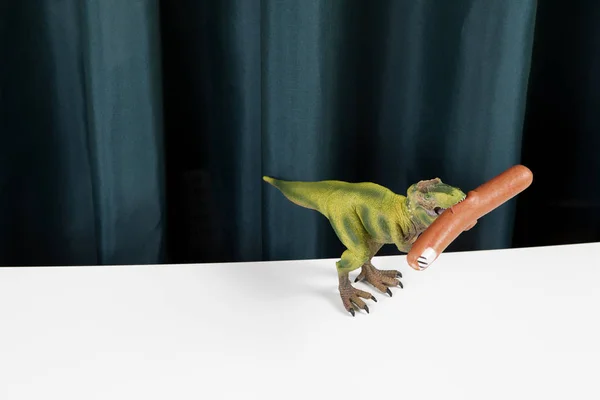 Curtain dinosaure eating sausage manicure — Stock Photo, Image