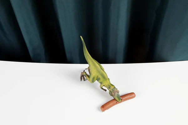 Curtain dinosaure eating sausage manicure — Stock Photo, Image