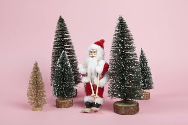 Pembe bir arka plan üzerinde Noel Baba kayak