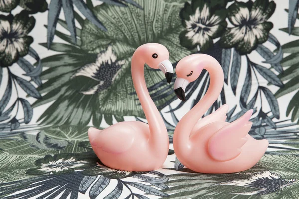 Couple of pink plastic flamingos on a tropical background — Stock Photo, Image