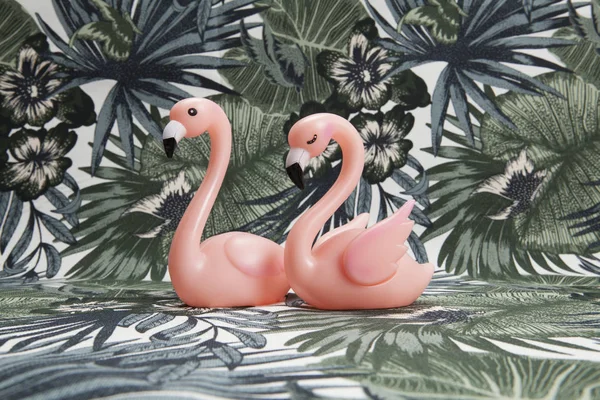 Couple of pink plastic flamingos on a tropical background — Stock Photo, Image