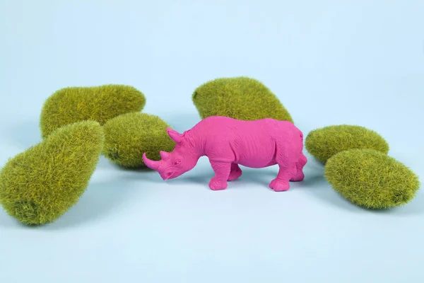 Rocce di muschio e rinoceronte di plastica pop rosa — Foto Stock