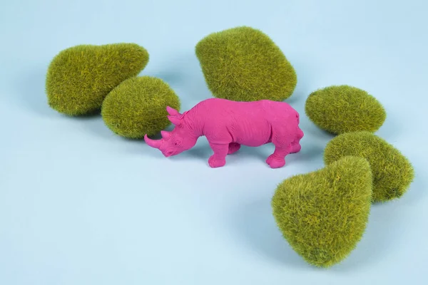 Moosfelsen und pinkfarbenes Plastik-Nashorn — Stockfoto