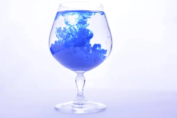 Blå Färg Vatten Ett Glas Vit Bakgrund — Stockfoto