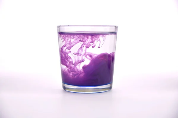 Vidrio Con Agua Sobre Fondo Blanco Con Pintura Púrpura — Foto de Stock