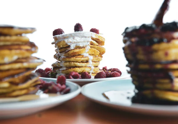 Pannkaka med rinnande yoghurt på en blå tallrik med hallon — Stockfoto