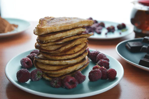 Läcker pannkaka dessert på en blå tallrik med hallon — Stockfoto