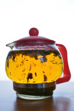 beyaz bir backgr üzerinde şeffaf bir çaydanlık zencefil ile demlenmiş çay