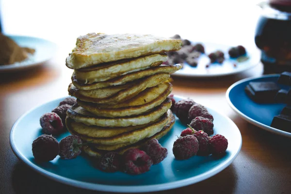 Läcker pannkaka dessert på en blå tallrik med hallon — Stockfoto