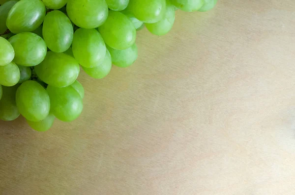 Zielone winogrona na szczycie drewnianej powierzchni teksturą. Zbliżenie z przestrzenią kopiowania — Zdjęcie stockowe