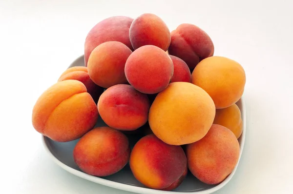 Isoliert frische saftige Pfirsiche Früchte und reife Aprikosen isoliert auf weißem Teller. Sommerfruchtkonzept. Nahaufnahme — Stockfoto