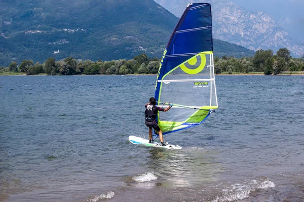 Lago de Como, Italia - 21 de julio de 2019. Deportes acuáticos: windsurf en un soleado día de verano cerca del Colico, ciudad de Italia. Montañas Alp en el fondo. Windsurf, deporte extremo . — Foto de Stock