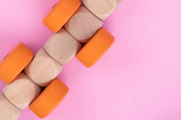 Top uitzicht op kinderen educatieve spel op licht roze papier achtergrond. Houten trein gemaakt van kubussen, oranje cirkels. Close-up — Stockfoto