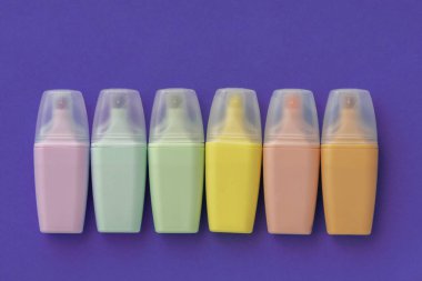 Renkli menekşe arkaplan üzerine işaretler konuldu. İşaretleyici koleksiyonu farklı renkte. Düz yerde, üst tarafta. Okula dönmek, eğitim kavramı..