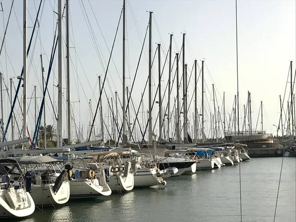 Hermoso yate amarrado en el puerto con otros barcos en azul sal — Foto de Stock