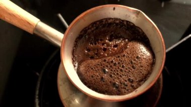 Bakır türk'ten sıcak lezzetli içecek hazırlayan Barista, cezve'deki küçük ateşte kahve için su kaynatıyor. Organik bakırdan yapılan kahve türkü, cezve den mutfağa. Cezve'de gerçek gurme kahve için bakır türk.