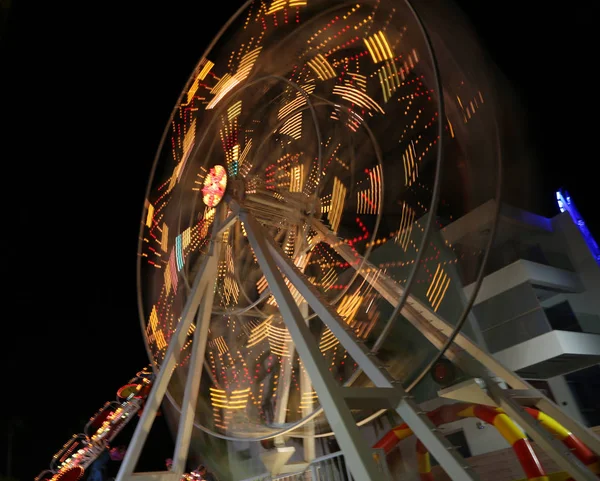 Round ferris wheel spins fast at black night