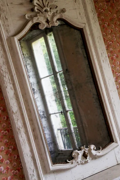 Beautiful wooden frame mirror in old building without people