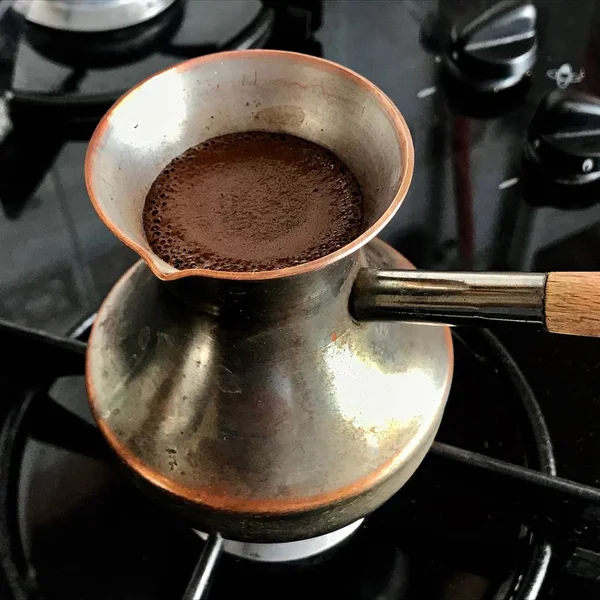 Бариста готовит горячий вкусный напиток из медного тюрка — стоковое фото