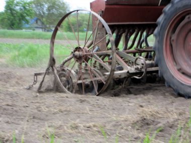 Açık kırsal alanda, kahverengi toprakta traktörle sürülmüş. Tarlada traktör, topraktan lezzetli sebzeler. Temiz mavi gökyüzünün altındaki organik tarlalar traktör için doğal topraktır..