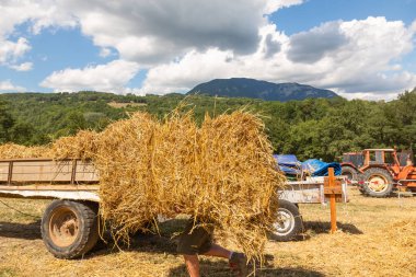 Tarım araçları ve alan arka plan üzerinde saman yığını. Fransa köy hasat.